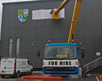 Cherry Picker used to apply a logo to the side of a building