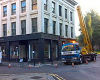 Cherry Picker coned off, preparing for work on a black and white store.